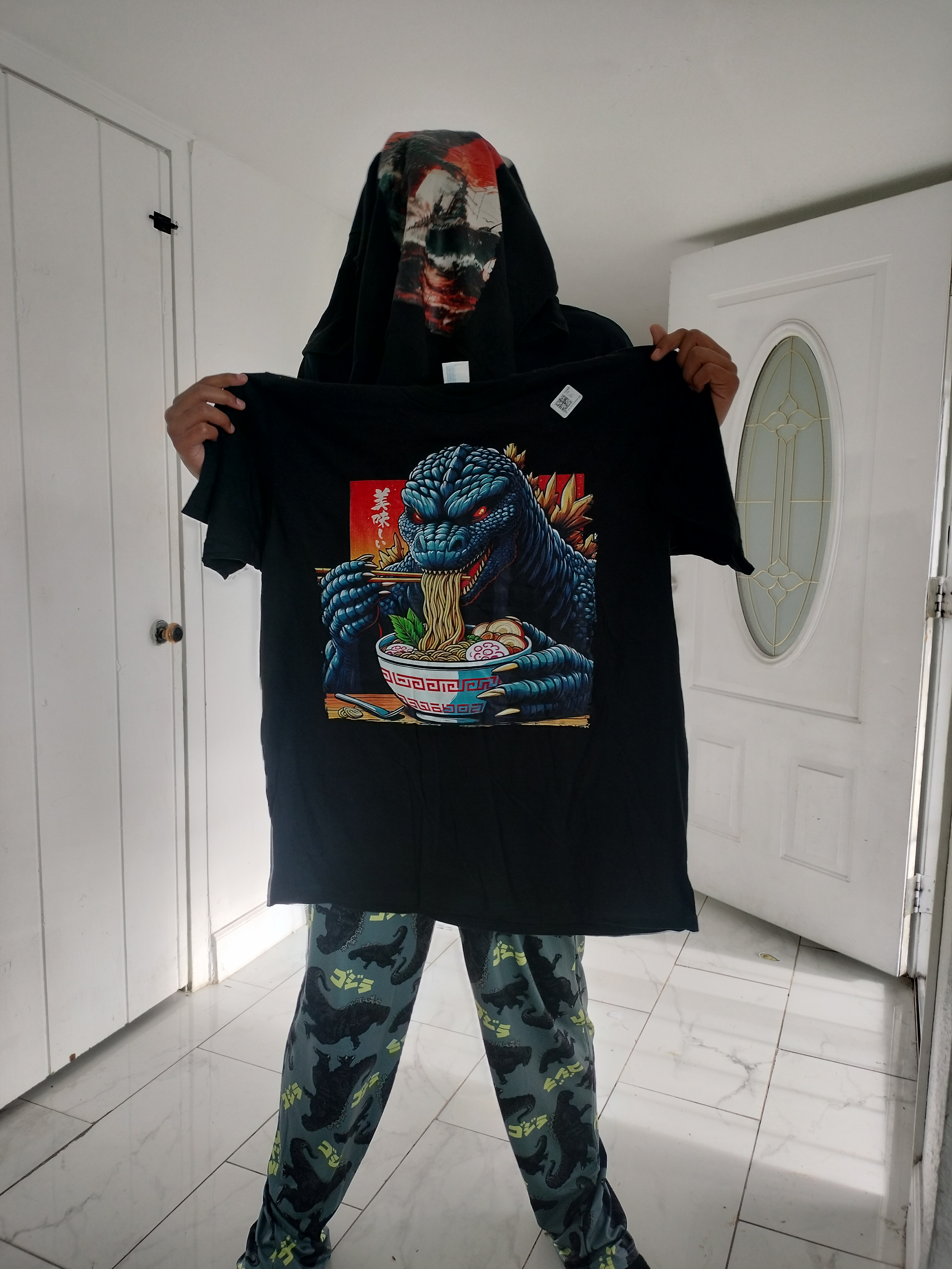 A child holding up a Godzilla shirt received for Christmas