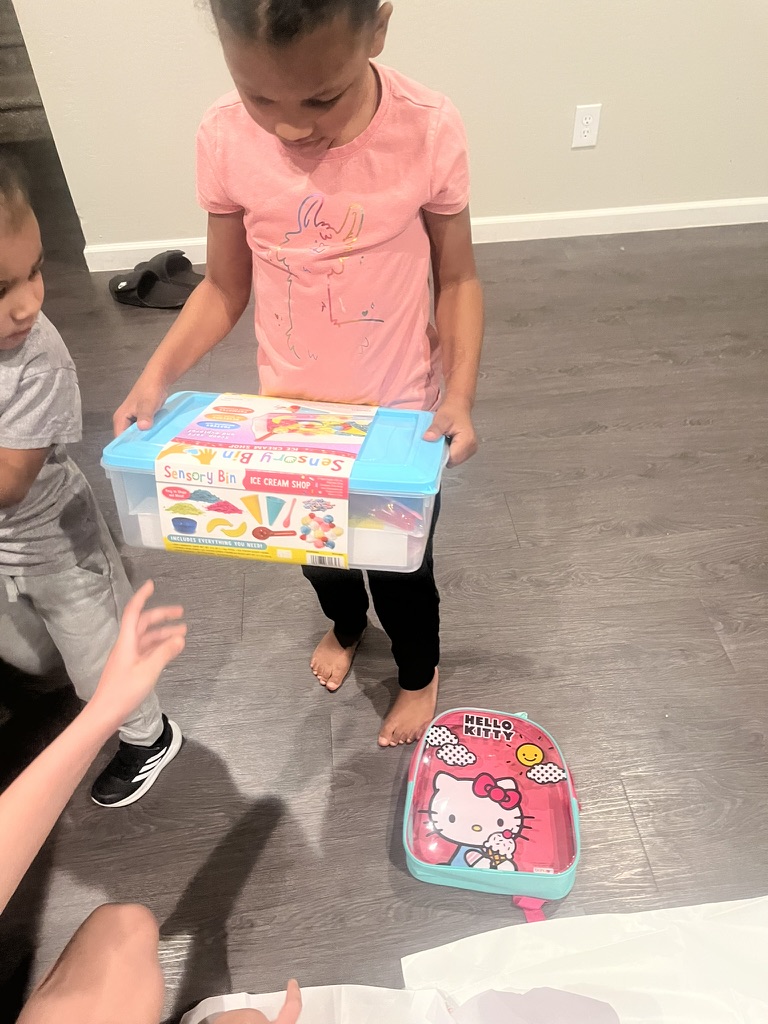 A child holding a sensory bin received for Christmas