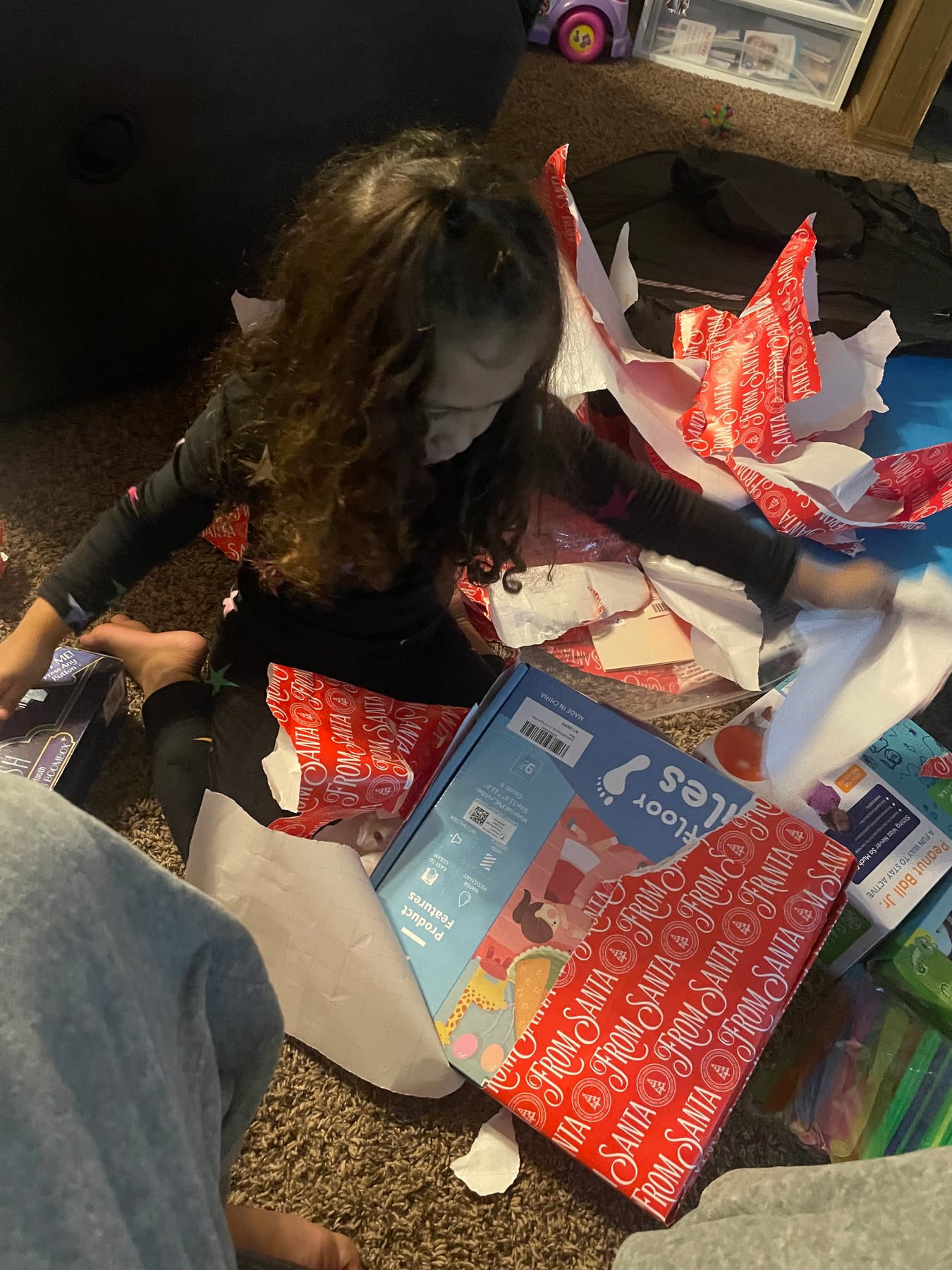 A child opening personalized holiday gifts at home