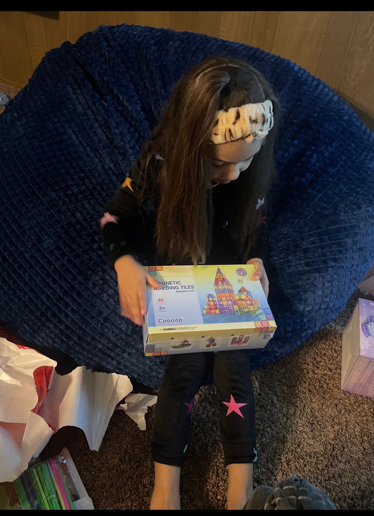 A child holding a magnetic building tile set