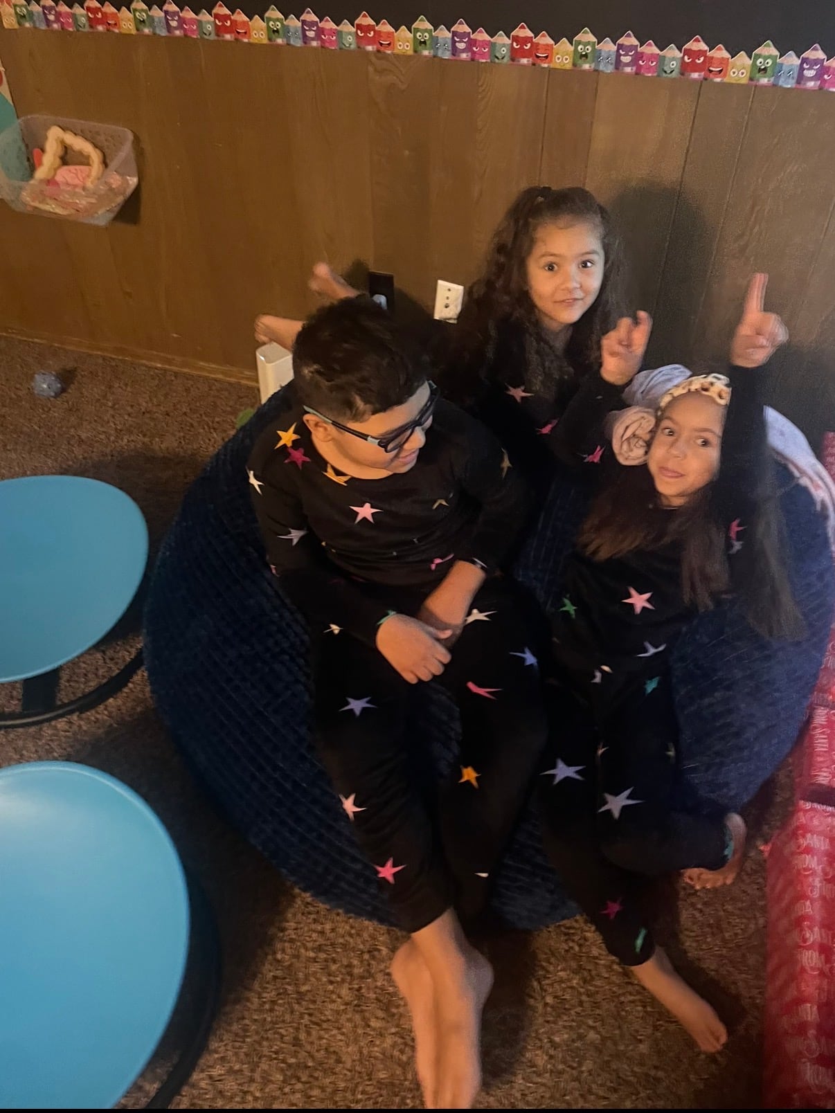 Three siblings relaxing together after opening their gifts