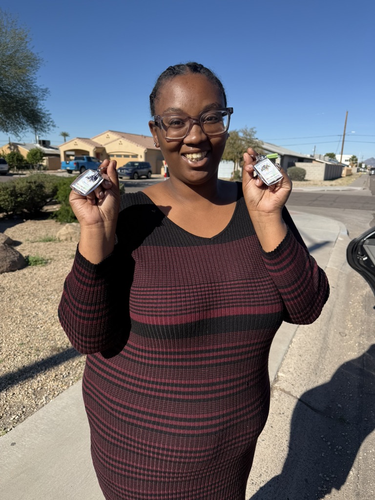 A smiling recipient holding two gift cards