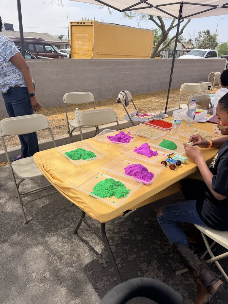 Colorful sensory activities arranged beneath a shaded event tent
