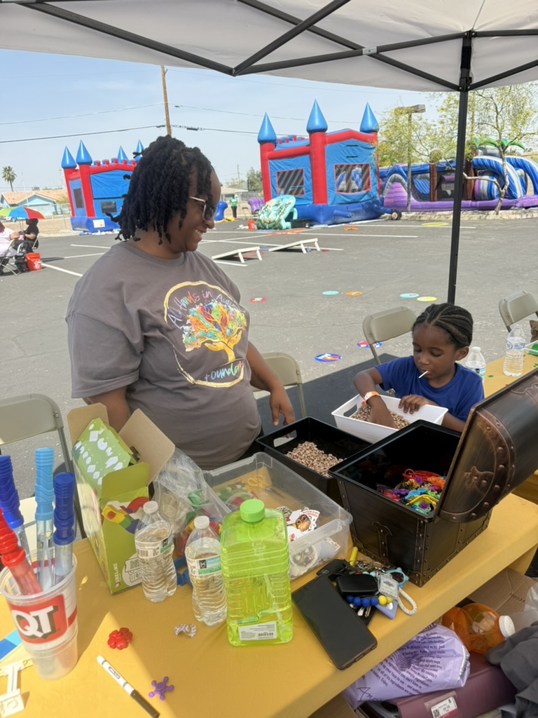 A volunteer supporting a child at a hands-on exploration station