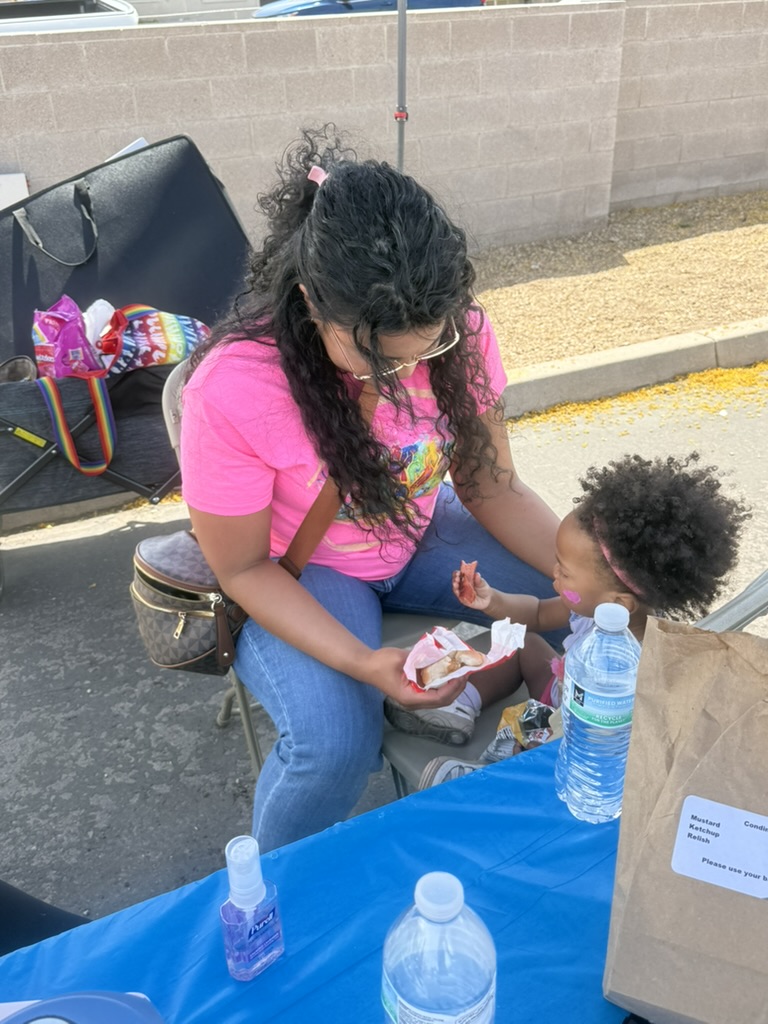 A caregiver sharing lunch with a young child at the community event