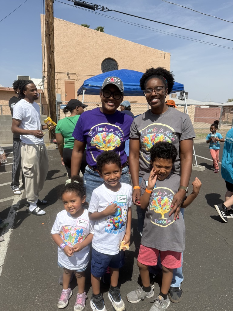 Foundation family members wearing All Hands in Autism Foundation shirts at a community event