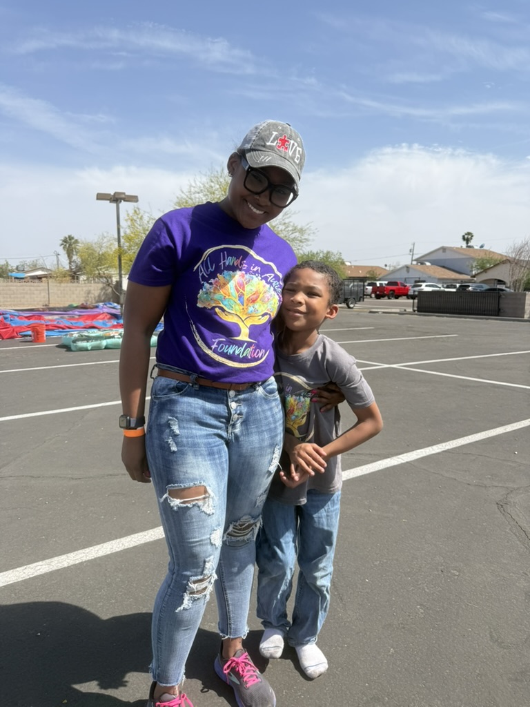 Sabrina Howard standing with a child at the foundation’s first community event