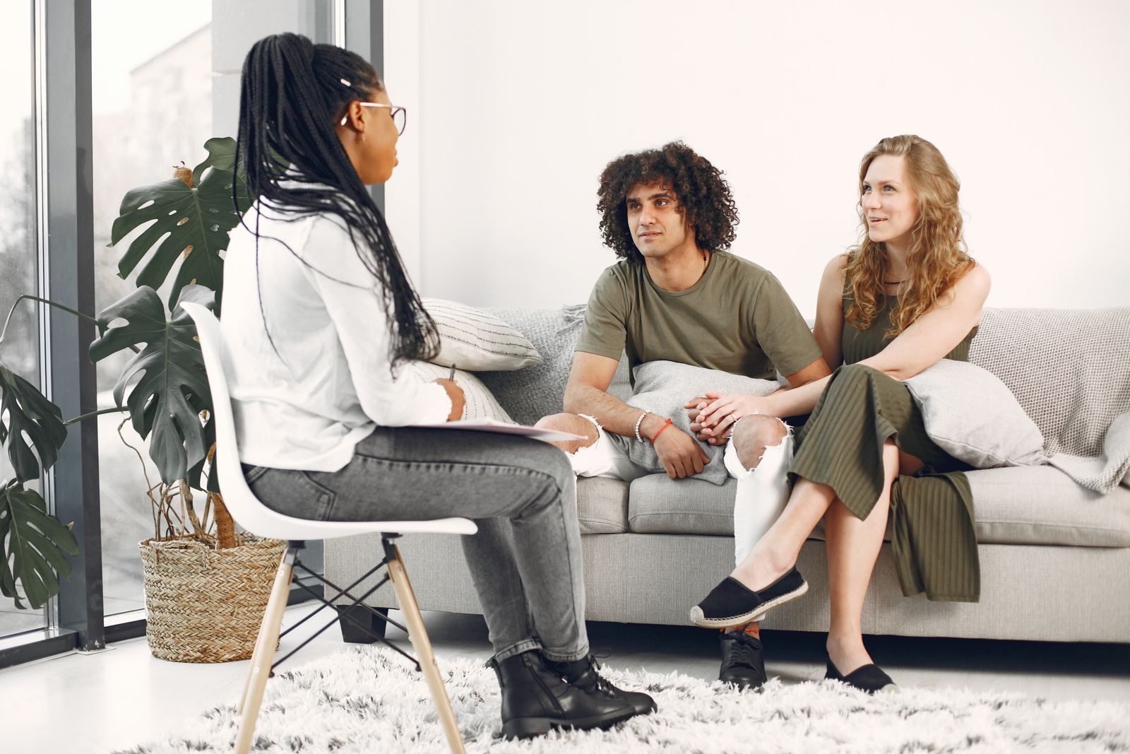 A couple speaking with a therapist in a bright, welcoming room