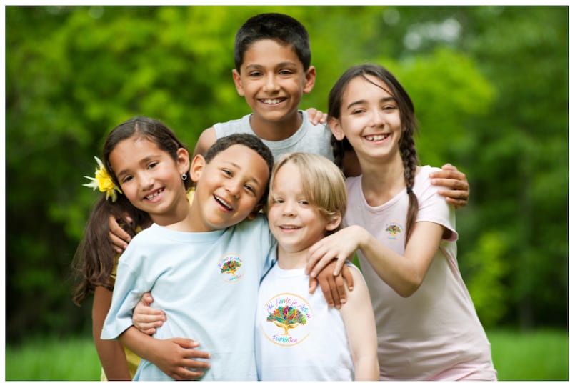 A diverse group of children smiling together outdoors