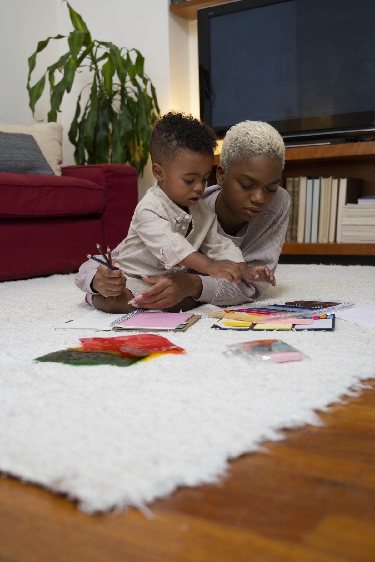 A caregiver and young child drawing together at home